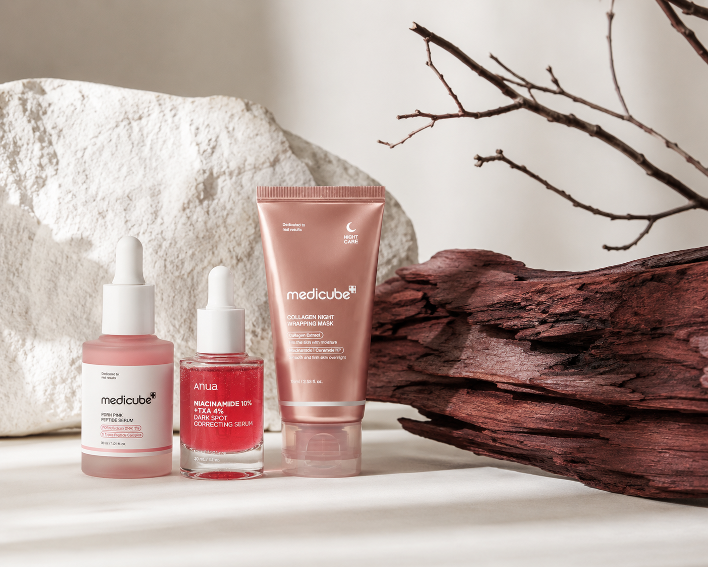 Korean skincare products arranged with ivory stone and burgundy wood